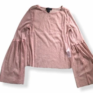 Transparent rosa tröja prickar  - Superfin transparent tröja som är väldigt snygg att ha på sig med en crop top under.den är rosa genomskinlig och prickig. Ärmarna är väldigt vida. Storlek 38.