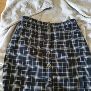 Kjol - Rutig kjol med knappar i storlek 38 från H&M. Använd ca 3 gånger. Bra skick. 