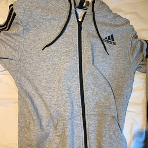 Adidas hoodie - En snygg grå adidas hoddie som kan användas till träning eller chill hoodie. Denna hoodie har knappt används och är i ny skick