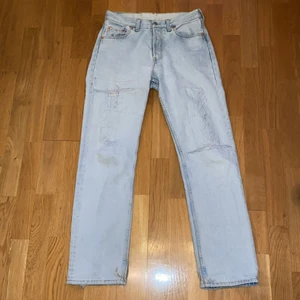 Levis 501 jeans  - Levis jeans i en ljusblå wash. Köpta second hand. Det är ett hål under fickan och slitningsdetaljer på benen. Mötas eller frakt mot avgift