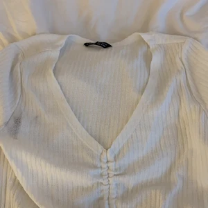 T-shirt - Ribbad vit t-short med v ringning och sjusterbar knyning på magen