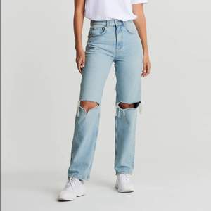 Highwaist jeans utan stretch med slitna knän. Jeansen är blåa och har en rak, 90-talsinspirerad passform. De är gjorda av denim och har en superhög midja, byxben med en fullängd och fickor fram och bak.