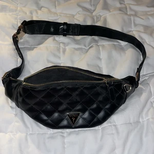 Guess magväska  - Min go to till alla fester är nu till salu. Riktigt fin magväska från Guess i läder (vet inte om det är äkta) och guldiga (inte äkta guld) detaljer. Liten ficka med dragkedja i, bältet går att justera. Riktigt bra skick! PS. Ni får även med två kedjor att sätta på väskan✨