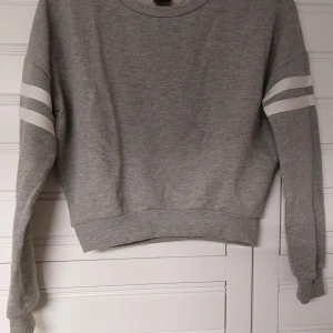 Sweatshirt  - Grå sweatshirt med vita detaljer från Ginatricot.