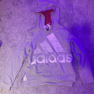 Grå adidas hoodie 140 - Trycket är inte slitet de är meningen att de ska vara så. Använt den typ 3 gånger för länge sen men har växt ur den.