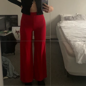 Röda byxor - Röda högmidjade utsvängda byxor från märket Rebecca Stella. Köpte de på second hand men är i bra skick (inte använt dem). Sydde upp dem då dem var långa på mig som är 165. Säljer för 60kr. Köparen står för frakten😊