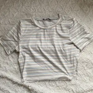 Supersöt randig t-shirt från Shein. Ränderna är i färgerna ljusblått, beigt och grå. Toppen är en aning croppad.