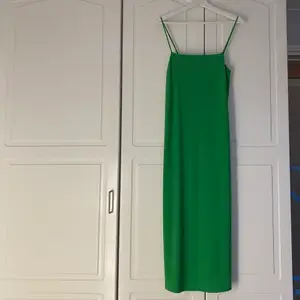 Grön klänning i satinliknande material. Använd 1 gång och i mycket gott skick.