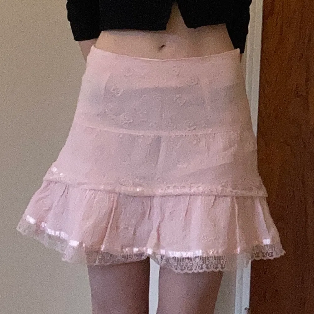 Söt rosa kjol med volanger. Har klippt den vilket märks på underkjolen men inget man kan se när kjolen väl är på. Något genomskinlig. . Kjolar.