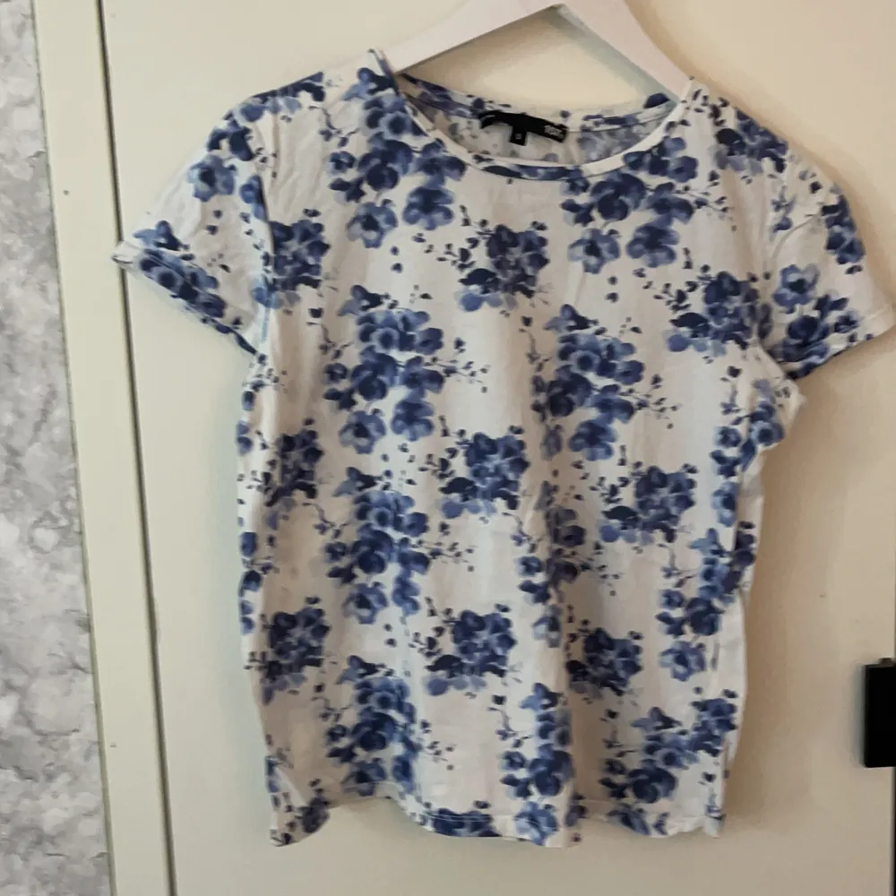 En vi kortärmad tröja med blå blommor på strl s väldigt fint skick frakt+pris. T-shirts.