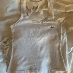 Lacoste linne - Checkar intresse på mitt vita Lacoste linne. Bra skick och inga synliga defekter. Hör av dig vid intresse💗