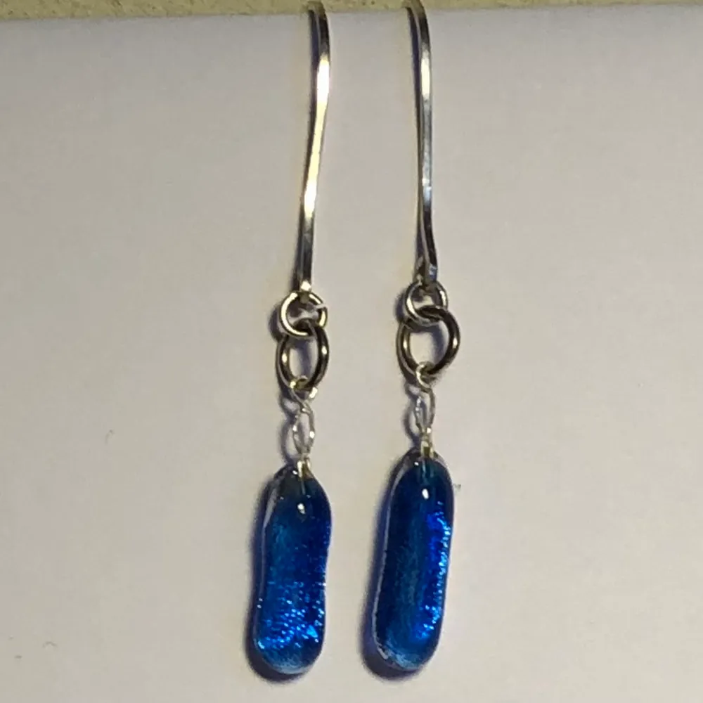 Handgjorda örhängen i blått glas och handgjorda örkrokar i fyrkantig silvertråd (Sterlingsilver ca 1 mm). Glasets baksida ger ett silvrigt intryck.. Accessoarer.