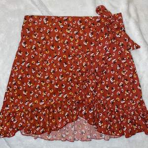 Blommig kjol, mörkröd från Ginatricot i storlek L (mer som en M). Bra skick.