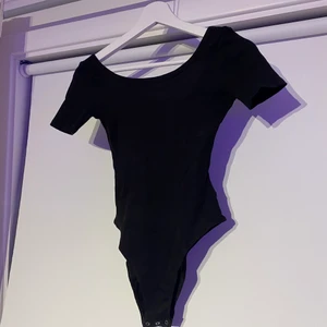 Svart body HM - Svart body från HM, lite ribbad. Tajt passform, storlek XS, knappt använd. Som ny!