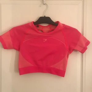 Gymshark Crop top M - Rosa träningstopp i stretchight från märket gymshark som är köpt second hand. Den är i bra skick utan synliga tecken på användning. Storlek M men skulle  nog kunna passa som S också då jag skulle skulle säga att den är liten i storleken.  Sista bilden är från gymsharks hemsida och du kan se passformen. Jag tar betalning via swish innan jag skickar varan och köparen står för fraktkostnad. Skriv gärnaom du har några frågor✨
