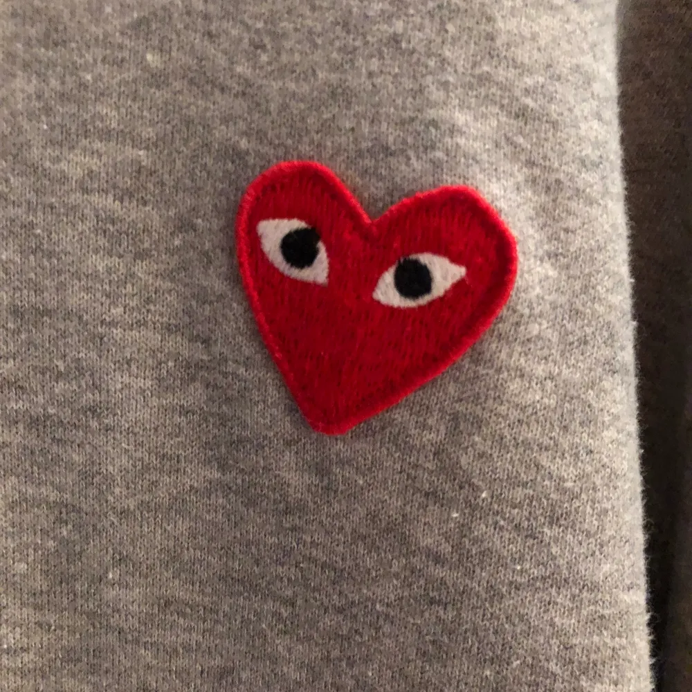 Grå Comme des Garcons play hoodie i väldigt fint skick och använd 2 gånger. Storleken är L men mer som M. Jag köpte den från End clothing för 2600kr. Tröjor & Koftor.