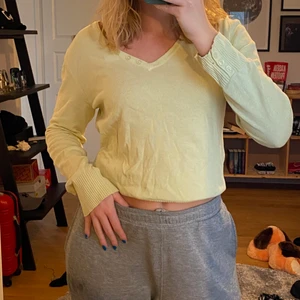 Tunn stickad tröja  - Tunn stickad tröja i ljusgrön/gul färg? Knappar vid halsen och handlederna. Fraktkostnad tillkommer. 