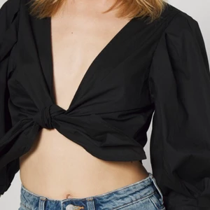 Tie front blus från Monki - Nästan oanvänd svart tie-front blus från Monki. Fin längd och puffiga ärmar. Säljer för att den inte passar mig🌸