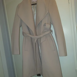 Kappa  - Petite-kappa Känn fördelarna Breda slag Stängs med knapp Skärp i midjan Slits bak Normal passform