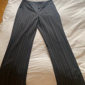 Randiga kostymbyxor - Extremt snygga randiga kostymbyxor, köpta second hand. De är strl 40 så lite stora för mig (obs håller in byxorna där bak på den bilden med byxorna på). De är vida längst ner.Jag är 164cm och dom går ner över fötterna och lite längre på mig. Jättebra skick! Startpris 150kr, buda i kommentarerna. 