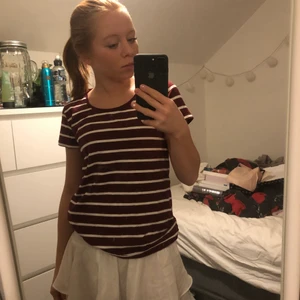 Randig t-shirt - Säljer min randiga, vit-röda t-shirt för att den inte kommer till användning. Den har en U-ringning och sitter lite tajtare men bekvämt vid magen. Passar jätte fint till ett par lågmidjade byxor. Den är ganska stretchig och i bra skick. 