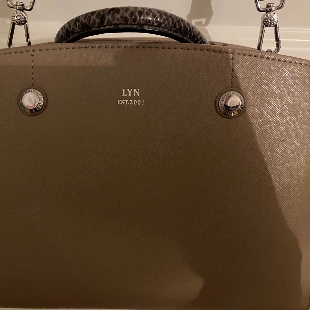 Jättesnygg brun/beige väska från LYN, som är ett Thailändskt design märke🤩 Köpte den för ungefär 900kr. Knappt använd och är som ny. Väskan är medel stor men rymmer väldigt mycket. Priset kan diskuteras! Köparen står för frakten❤️. Väskor.