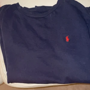 Marinblå Ralp Lauren t-shirt man storlek 160 CM - Jag säljer min Marinblå Ralp lauren t-shirt som är otroligt snygg och modern och som inte har några fläckar.