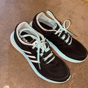 Adidas skor  - Adidas skor som är svarta/ vit med turkosa skosnören, använda max 3 gånger så dem är som nya! Storlek 38 men skulle säga att dem passar en 37 också! Säljer för 700kr eller buda! Köparen står för frakten 