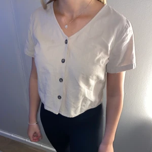 Linne t-shirt  - T-shirt i linne material beige superfin med knappar, lite croppad