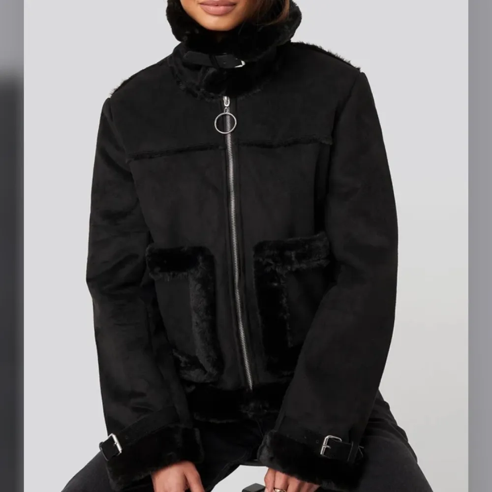 Svart FauxSuede Fur Jacket från NA-KD, i storlek 36. Den har en krage, en dragkedjestängning på framsidan, framfickor och skärpdetaljer vid nacken och på muddarna. Originalpriset är 899kr. Köparen står för frakten. . Takit.