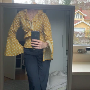 Volang blus  - Gul och prickig blus med volanger och visa armar med slits 