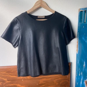 ”Läder” T-shirt  - Fejk läder T-shirt med skönt material på insidan! Köpt i en fin liten butik på hydra, Grekland. Skitsnygg o passar till allt men används tyvärr inte längre. Frakt tillkommer 🍋