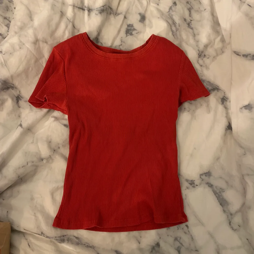 En röd ribbad T-shirt i storlek M. Sitter fint jämt ut med kroppen. . T-shirts.
