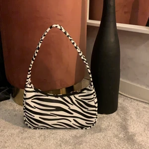 Fin väska i zebramönster  - Säljer en fin axelväska i zebramönster, inga innerfack, men bra skick. Har bara använts 2 gånger därför den säljs.