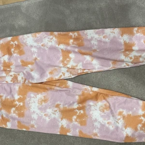 Tiedye strl 11-12 år - Svart, orange, vit mönstrade Tiedye mjukis byxor. Väldigt sköna från shein. Säljer dessa på grund av att dom börjar bli för små🥺. Köparen står för frakten som är spårbar och kostar 66 kr för leverans eller 45 för upphämtning. Priset för byxorna kan diskuteras. 