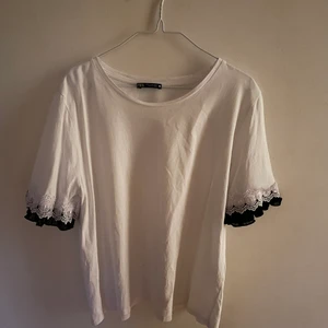 Zara vit T-shirt, XL  - En vit tshirt från zara i storleken Xl. Liten till storleken, M skulle vara mer rätt storlek. Den har volanger i armarna i svart.  
