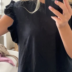 Volang t-shirt  - Super fin t-shirt med en volang vid ärmarna! Knappt använd och i bra skick. Storlek M🖤 köparen står för frakt och betalning sker via swish 