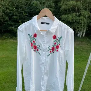 Säljer en vitskjorta med ett tryck av röda roser på bröstet. Från BikBok i storlek S. Använd fåtal gånger, sitter bra och bekvämt. Utgångspris 70kr, frakt ingår ej. 