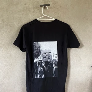 Svart t-shirt - Svart t-shirt med tryck på ryggen. Köpt från ett uf-företag i storlek s, men är lite större i modellen!