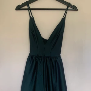 Kort jumpsuit Urban Outfitters - Grön kort jumpsuit med djup v-ringning från Urban Outfitters. Den är för kort för mig som är 168 så den kommer inte till användning. 