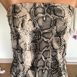 Snakeprint kjol - Säljer denna fina snakeprint tub-topp som man även kan använda som kjol. Den är i mer bikini matrieal vilket gör den stretchig. Den har även dubbelt med tyg vid brösten så man får mer stöd & täckning. Den är i Xxs men den passar mig som är xs också. Riktigt snygg party topp eller kjol. Aldrig använt dock då de inte är min stil. Jag tar endast swish & köparen står för valfri frakt, frakten ingår inte i priset🌸
