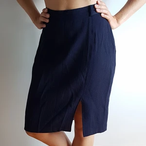 Marinblå knälång kjol med slits - Marinblå, knälång kjol med slits framtill, samt en knapp och dold dragkedja baktill. Underbar 90-talskjol från H&M womens collection, som min mamma burit under 90-talet.