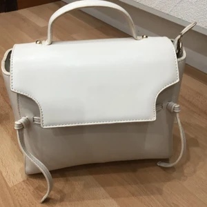Väska - Säljer en super fin enkel vardags väska som passar till allt och är i färgen ”kräm vit”.  Ett längre band medföljer också.
