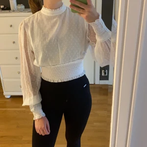 Vit blus - Oanvänd vit blus från NA-KD i storlek 36. Lite kortare modell med resår. Knytning där bak.