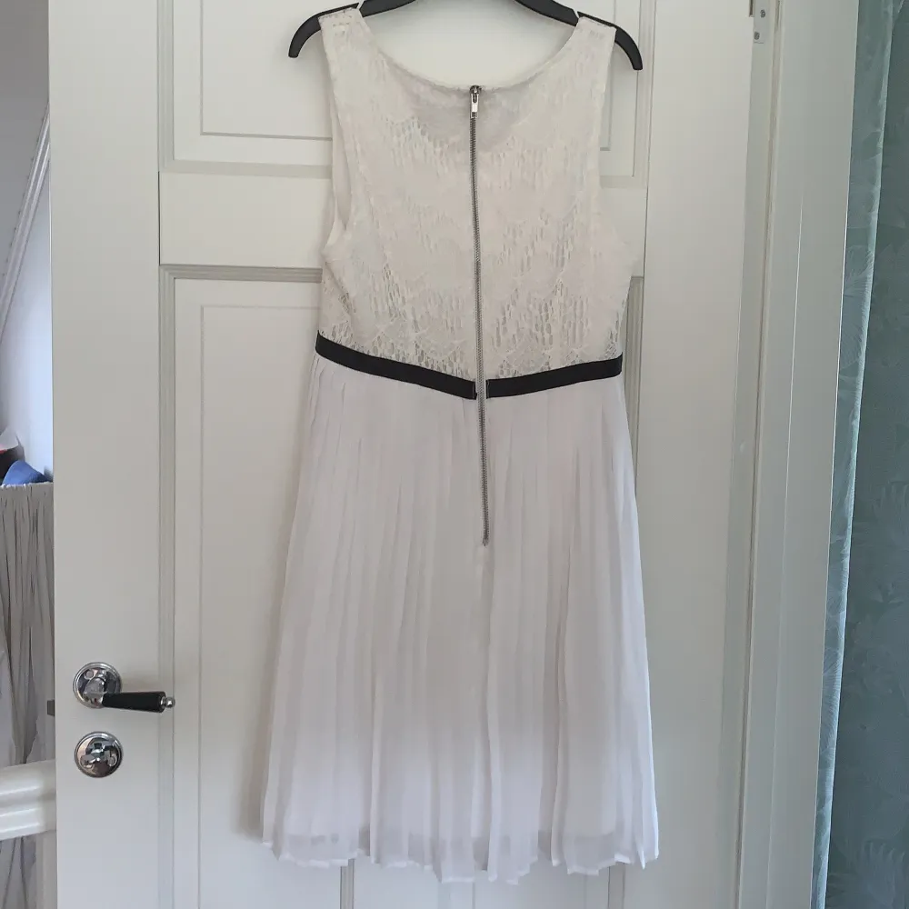 A knee long, white dress with a black strap. Both casual and pretty. Size S. . Klänningar.