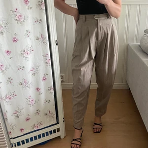 Beige kostymbyxor  - Beige kritstreckrandiga kostymbyxor från Weekday i lite mer loose passform, storlek 34.🤎 Frakt tillkommer enligt nedan.