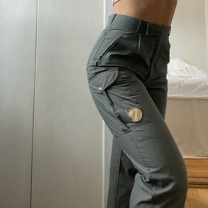 Fjällräven cargo byxor - Knappt använda fjällrävenbyxor, köpta second hand. Grön/grå i färgen och hög midja. Sitter mycket smickrande. Har mer bilder om så önskas!