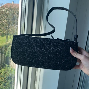 Väska  - Säljer denna glittriga väska då jag aldrig använt den.