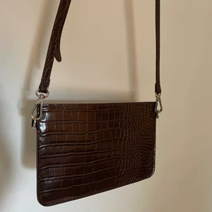 Carin Wester väska - Säljer denna mörkbruna väska från Carin Wester då den inte kommer till användning längre. Ormskinns struktur. Möts upp i Västerås och eventuellt Stockholm. Betalning via Swish.💕