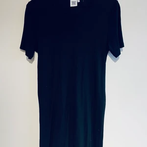 Svart klänning stl M - Jättefin stretchig klänning i T-Shirt modell som går till precis ovan knäna. Stl M. Sparsamt använd och i fint skick. Inköpt i Berlin.